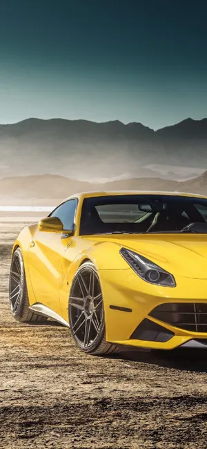 Stunning Ferrari F12 Powering Through Desert Landscape On An Iphone Background Wallpaper