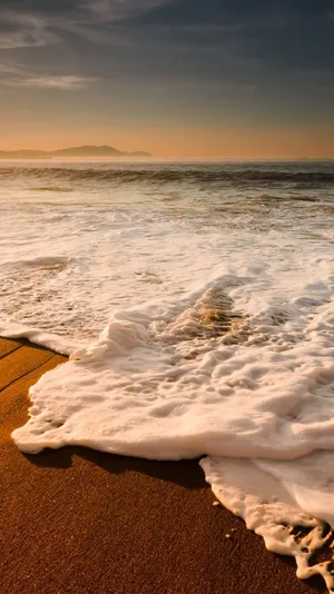 Take In The Beauty Of An Idyllic Sunset On The Beach With Your Iphone For An Unforgettable Moment. Wallpaper