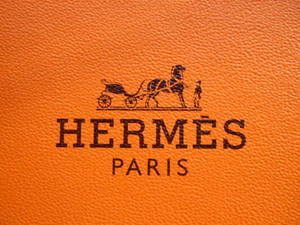 Textured Orange Hermes Logo Wallpaper