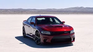 The Red Dodge Charger Srt Is Parked In The Desert Wallpaper