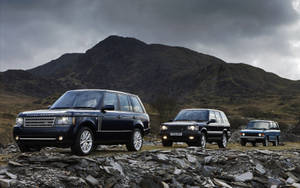 Three Land Rover Cars In A Variety Of Colors Wallpaper