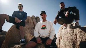 Three Men Sitting On Rocks In The Sun Wallpaper