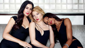 Three Women In Black Dresses Posing For A Photo Wallpaper