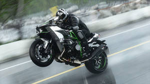 Thrill-seeker Riding High On A Black Kawasaki H2r Wallpaper