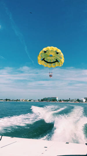 Thrilling Adventure At Sea - Parasailing Behind Speed Boat Wallpaper