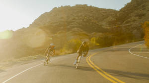 Thrilling Downhill Cycling On A Country Road Wallpaper