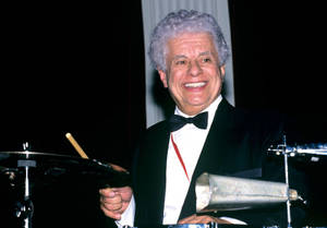 Tito Puente Smiling While Drumming Wallpaper