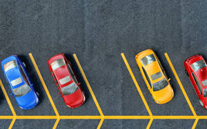 Top View Of A Structured Parking Lot With Yellow Lines Wallpaper