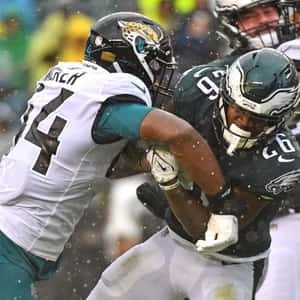 Travon Walker Tackling Miles Sanders Wallpaper