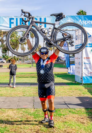 Triathlon Athlete Carrying His Bike Wallpaper