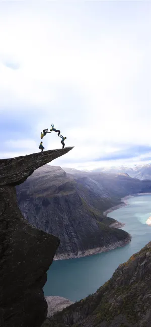 Trolltunga With Tourists Doing Backflips Wallpaper