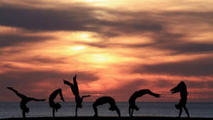 Tumbling Silhouette Beach Sunset Wallpaper