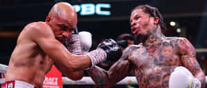 Two Boxers With Tattoos Fighting In A Boxing Ring Wallpaper
