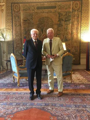 Two Gentlemen Standingin Ornate Room Wallpaper