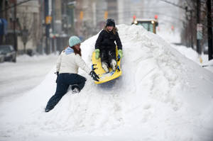 Two Girls Sledding On The Snow Wallpaper