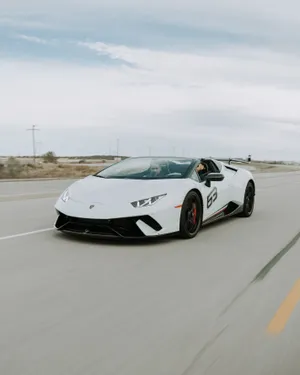 Two Men Driving White Lamborghini Huracan Spyder During Daytime Wallpaper