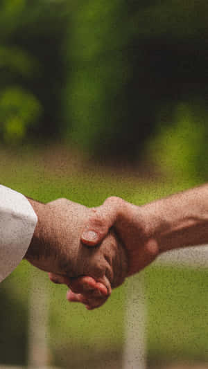 Two Professionals Engaging In A Handshake Wallpaper