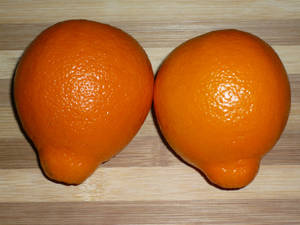 Two Tangelo Fruits On Chopping Board Wallpaper