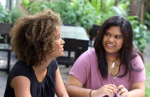 Two Young Women Talking Wallpaper
