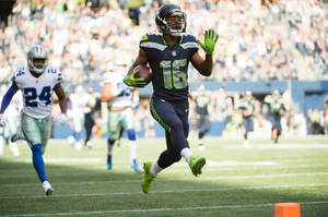 Tyler Lockett In Action On The Football Field Wallpaper