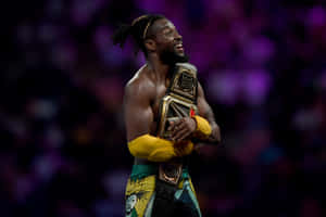 Victorious Kofi Kingston Hugging His Wwe Belt Wallpaper