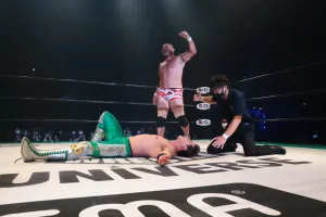 Victorious Wrestler Standing Over Opponent Wallpaper