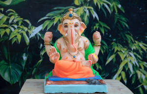 Vinayaka Figurine In Green And Orange Clothes Wallpaper