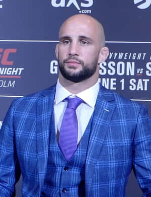 Volkan Oezdemir Posing In A Plaid Suit And Tie Wallpaper