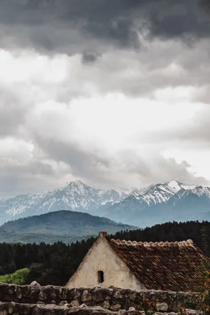 White And Brown House Near Trees And Glacier Mountains At The Distance Wallpaper