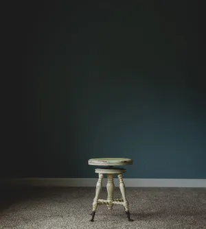 White Wooden Stool Chair In Dark Room Wallpaper