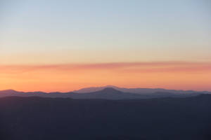 Witness Sunrise Over Beautiful Mountain Peaks Wallpaper