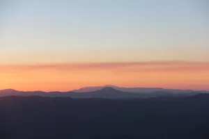 Witness Sunrise Over Beautiful Mountain Peaks Wallpaper