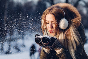 Woman Blowing Snow On Her Hands Wallpaper