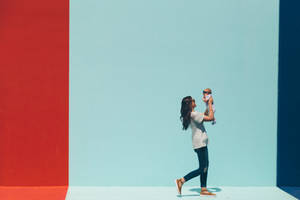 Woman Carrying Baby While Walking Wallpaper