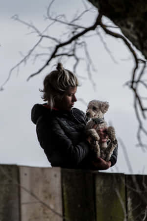 Woman Holding Dog Affectionately Wallpaper