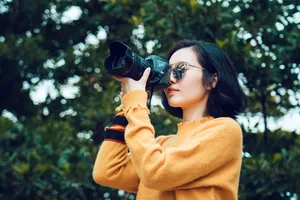 Woman Taking Photo Near Tree Wallpaper