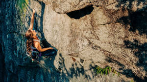 Woman Toughly Climbing On A Rock Wallpaper