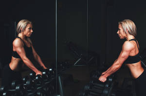 Woman Weightlifting In Gym Wallpaper