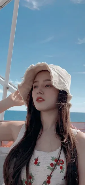 Womanin Bucket Hat Ocean Backdrop Wallpaper