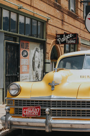 Yellow Vehicle Parked Next To Building Wallpaper