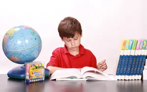 Young Boy Reading Educational Books Wallpaper