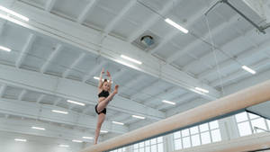 Young Girl Balancing On Balance Beam Wallpaper